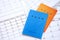 Japanese pension insurance booklets on table with calendar. Blue and orange pension book