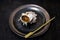 Japanese shellfish Sazae or Sadae grill with Japanese bamboo stick on black pottery dish place on table,turbo shell do hot grill i