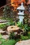 Japanese stone lantern in the garden with cho-zu fountain and maple. Traditional asian fountain in the park.