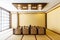 Japanese style dining room with wooden table in the center and eight cushion seats decorated in earth tone