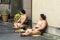 Japanese Sumo Wrestlers are Sitting and Resting on The Ground on a Street