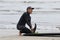 Japanese Surfer wearing a black wetsuit with a surfboard.