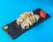 Japanese Sushi Roll - Warm Sushi Roll with Salmon and Cream Cheese served on a black board over bright blue background