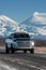 Japanese SUV Toyota Tundra driving along road on background of Kamchatka winter landscape - active Kluchevskoy Volcano