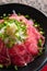 Japanese Tataki raw beef cuisine with ginger, onion, spring onion and soy sauce set on red wooden tray