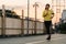 Japanese teen girl wearing sports clothes on walkway bridge in early morning.