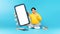 Japanese Teen Guy Showing Large Phone Sitting On Blue Background