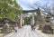 Japanese tourists strolling along the sacred sandÅ path of Miyajidake Shrine overlooked by  multiple stone Torii portals.