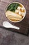 Japanese vegetarian shiro miso soup with tofu, enoki mushrooms, wakame seaweed close-up in a bowl. Vertical top view