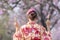 Japanese woman in traditional kimono dress holding sweet hanami dango dessert while walking in the park at cherry blossom tree