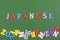 JAPANESE word on green background composed from colorful abc alphabet block wooden letters, copy space for ad text