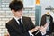 Japanese young man in suit, wearing glass, watching documents with tablet device