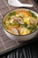 Japanese Zosui rice soup with egg, mushrooms, vegetables and chicken meat close-up in a bowl. vertical