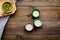 Japanise tea ceremony with matcha tea. Bowl with powder and cups with beverage on tablecloth on dark wooden background