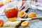 Jar of apricot jam and fresh apricots on wooden table