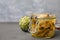 Jar of delicious artichokes pickled in olive oil on grey wooden table, closeup. Space for text