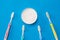 A jar of dental powder and a set of silicone toothbrushes on a blue background.