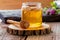 Jar of fresh honey with honey dipper on  wooden slice and  boards close-up  with flowers