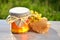 Jar full of delicious fresh honey piece of honeycomb and wild flowers