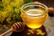 Jar of golden honey surrounded by buzzing bees on a sunlit day in the countryside