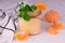 A jar of healthy tangerine smoothies garnished with a mint twig. Close-up.