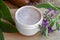 A jar of homemade comfrey root ointment with comfrey flowers and
