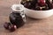 Jar of Homemdae Cherry Jam on a Rustic Wooden Table