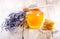 Jar of honey with honeycomb and lavander flowers