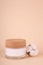 A jar of moisturizer and cotton sprig on beige background. Natural beauty product, organic cosmetics creative concept. Detailed