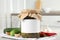 Jar of pickled cucumbers with blank sticker on grey table in kitchen