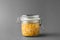 Jar of pickled sweet corn on background