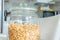 Jar of plain granola, made from toasted oats, as museli, on kitchen table in daylight, for breakfast food