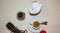 Jar with spilled coffee beans on linen tablecloth with cup of espresso full with spoon.