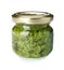 Jar of tasty pesto sauce on white