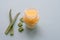 Jar of wax moisturizing cream with slices of aloe vera plant on pale green background.Revitalizing soft cream as organic moisturiz