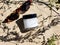 Jar with white cream and black lid. Mock up cosmetics, sunglasses and trendy herb shadow on the beach sand