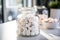 A jar of white marshmallows on a wooden table, with a blurred kitchen background