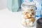 Jar with white sugar cubes and brown cane sugar lump on the white kitchen table