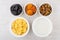 Jar of yogurt, corn flakes and dried fruits in bowls