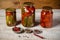 Jars with assorted fermented cucumbers and tomatoes with seasonings