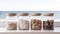 Jars containing beach pebbles and sand on window sill with beach view. Concept of summer holiday