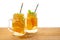 jars of homemade lemonade with sliced fresh lemon, orange, lime, twig mint, bubbles and straws on wooden background isolated, con