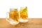 Jars of homemade lemonade with sliced fresh lemon, orange, lime, twig mint and bubbles on wooden background isolated, detox fruit