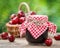 Jars of jam and basket with cherry.