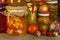 Jars with marinated food and organic raw vegetables. Preserved vegetables on wooden background. Various marinaded food. Life on a