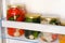 Jars of various homemade pickled vegetables on shelf of refrigerator. Fermented healthy natural vegetarian food concept