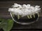 Jasmine floating in clear glass on wooden background