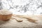 Jasmine rice in a wooden bowl, spoon and ear of rice on wooden background and bokeh backdrop