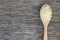 Jasmine rice in wooden spoon on rustic wood background.