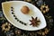 Java pepper, nutmeg and star anise on a decorative plate